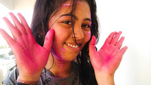 Close-up Portrait Of Smiling Young Woman With Powder Paint During Holi