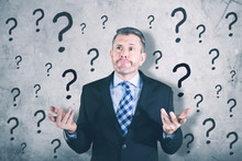 Confused Businessman Standing With Question Mark