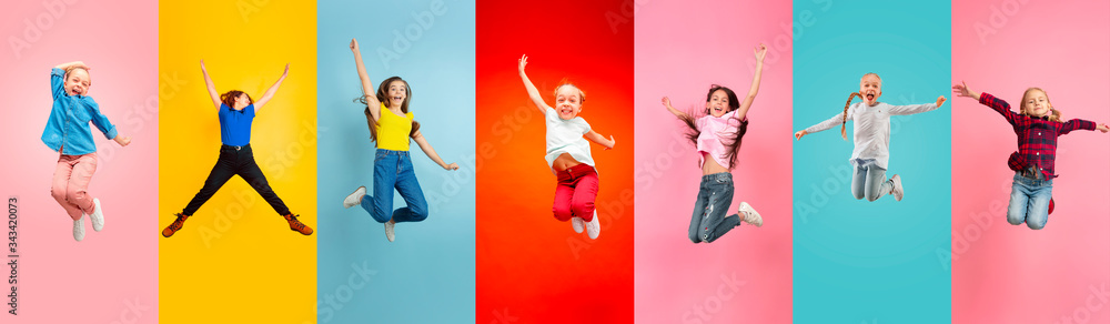Emotional kids and teens jumping high, look happy, cheerful on multicolored background. Delighted, winning girls. Emotions, facial expression concept. Trendy colors. Creative collage made of 5 models - obrazy, fototapety, plakaty 