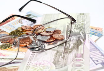 glasses coins and currency on white background