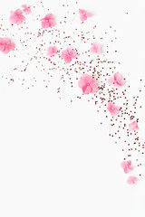 Wall Mural - Confetti of Gold glitter and pink flowers splash on white background. Spring Holidays frame. Birthday, Mothers Day, wedding. Copy space.