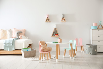 Poster - Small table and chairs with bunny ears in children's room interior