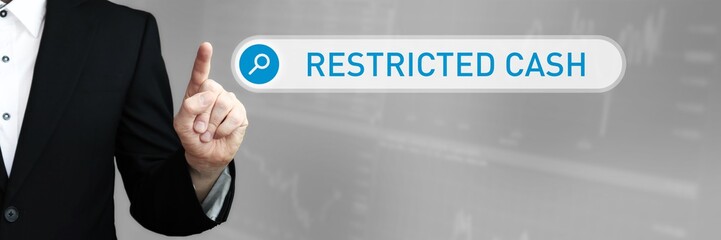 Restricted Cash. Man in a suit points a finger at a search box. The word Restricted Cash is in the search. Symbol for business, finance, statistics, analysis, economy