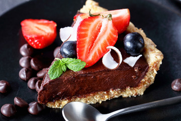 Canvas Print - Piece of vegetarian chocolate tart on black plate