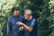 © chokniti - Old father and adult son are relaxing in the backyard