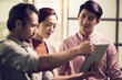 © imtmphoto - three young asian entrepreneurs working together in office using digital tablet