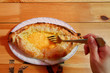Mixing Cheese and Egg with Fork Before Eating Adjaruli Khachapuri, Traditional Georgian Bread Served on Wooden Table