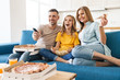 © Drobot Dean - Photo of cheerful family eating popcorn and pizza while watching tv