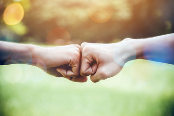 hands of two man people fist bump team teamwork and partnership business success. volunteer charity 