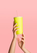 Female Hands Holding Disposable Cup With Refreshing Summer Drink On Pink Background, Closeup. Empty Space For Design