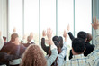 © Stella - Business people raising hand up to ask question with speaker in seminar conference, raise hands up to agree or vote for comments in the meeting