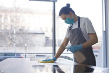 Young Woman In Mask And Gloves Making Disinfection Of Kitchen