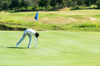 © freebird7977 - Golfer man playing golf aiming shot for putting ball on the hole with club on green course.  Professional people hobby in holiday and vacations in sunny morning day on club golf.