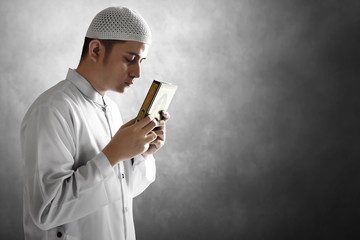 Religious asian muslim man holding holy quran