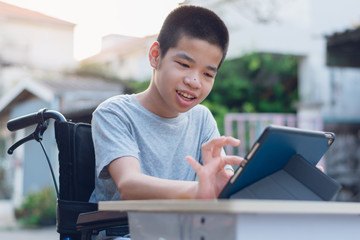 Wall Mural - Disabled child on wheelchair happy time to use a tablet in the house, Study and Work at home for safety from covid 19, Life in the education age of special need kid, Happy disability boy concept.