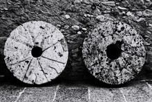 Old Stone Wheels Against Wall