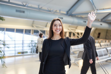 Canvas Print - Young business woman while waving in the airport