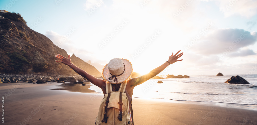 Happy woman with arms up enjoy freedom at the beach at sunset. Wellness, success, freedom and travel concept - obrazy, fototapety, plakaty 