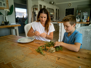 Mother and son make round frame from twigs