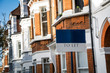 Estate agency 'To Let' sign with red brick British terraced houses behind
