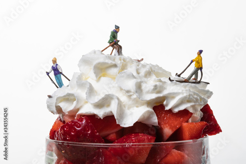 Cuadros en Lienzo Montaña de fresas con nata y esquiadores en miniatura.