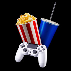 Canvas Print - Flying popcorn, drink and video game joystick gamepad isolated on a black