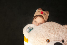 Little Sad Child In A Sleep Mask Hugs A Toy Of A Big Teddy Bear.