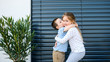 © Halfpoint - Small girl and boy standing outdoors at home, hugging.