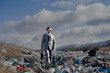 Modern businessman on landfill, consumerism versus pollution concept.