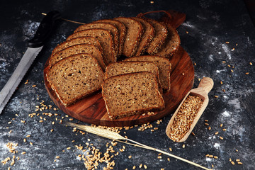 Sliced rye bread on cutting board. Whole grain rye bread with seeds on table