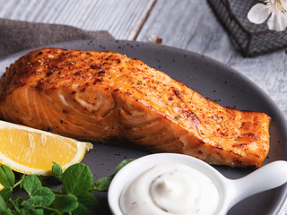 roasted baked salmon fillet with lemon, white sauce and pea sprouts