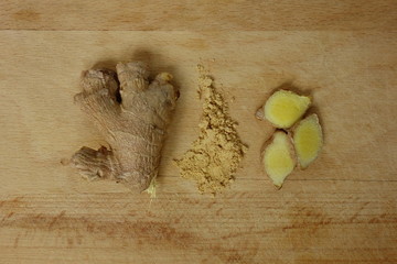 Wall Mural - Ginger spice as root, slices and powder on wooden plate