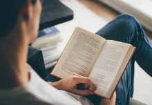 Midsection Of Man Reading Book