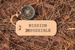 Magnetic compass and paper tag with words Mission impossible changed to Mission Possible at outdoor. Conceptual image with selective focus