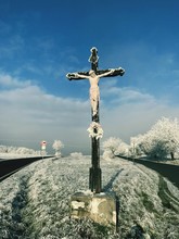 Statue On Cross Against Sky During Winter
