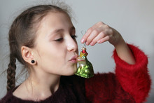 Close-up Of Girl Kissing Frog Ornament