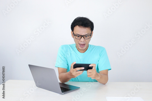 Fotografía Angry Asian young man get mad on the smartphone when play game at work