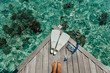 Beach vacation snorkel girl snorkeling with mask and fins. Equipment for snorkeling. Woman legs on wooden pier with snorkeling equipment