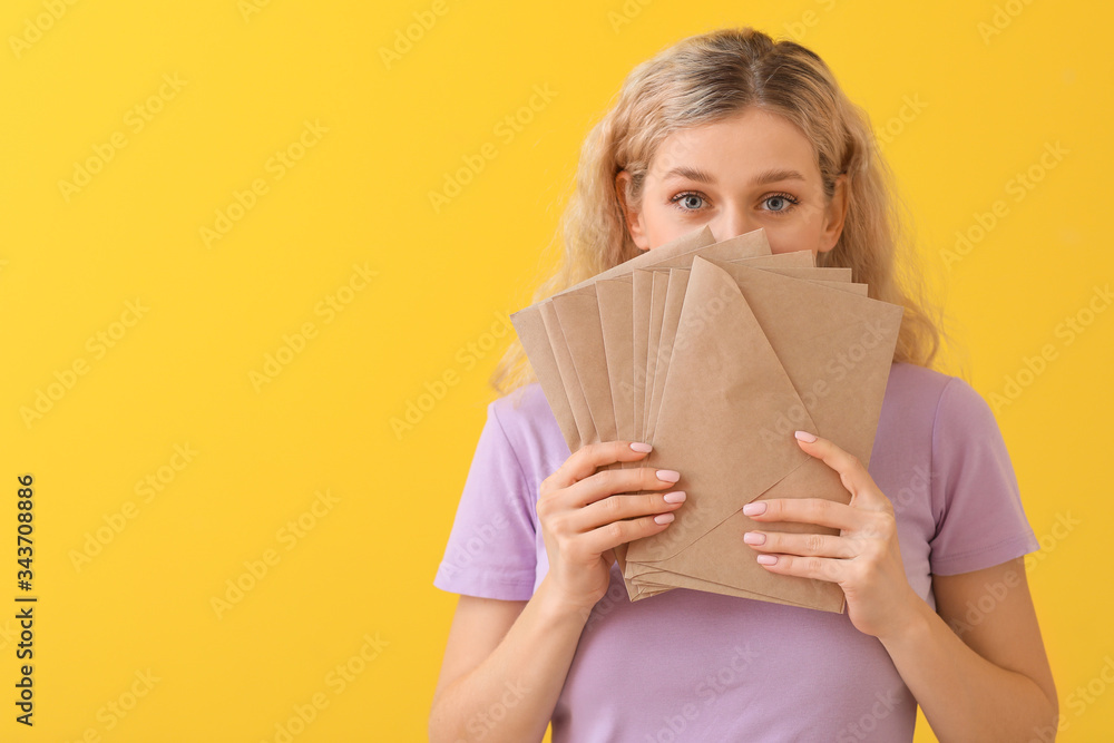 Young woman with letters on color background