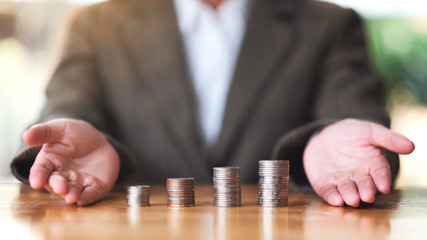Wall Mural - businesswoman showing stack of coins on the table for saving money concept