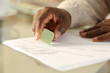 © PheelingsMedia - Black man hands erasing drawing with rubber on a desk