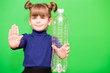 © Svetlana - Little girl with plastic bottle and open hand say stop of plastic pollution, recycling plastic, plastic free isolated on green