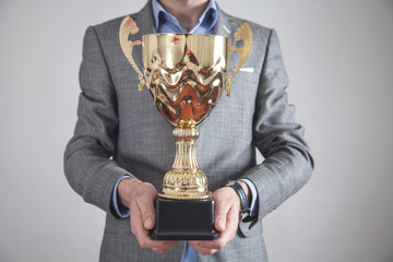 Wall Mural - Businessman holding golden trophy. Business, Success