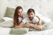 © hetmanstock2 - Cute couple in a bedroom. Lady in a white t-shirt. Pair at home
