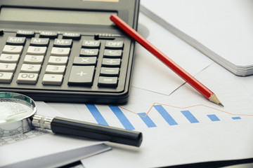 Business financial documents, office calculator and pen on the table. Numbers and graphs