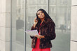 © hetmanstock2 - Black woman. Lady in a red dress. Student hold folder with documents in his hands.
