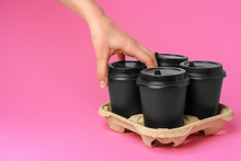 Coffee Delivery. Human Hand Holding Takeaway Coffee Cup On Paper Background