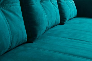 Closeup of trendy blue sofa with cushions on it.Velvet texture of comfortable couch