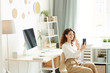 © Seventyfour - Young businesswoman having video conference with her colleagues using smartphone while staying at home