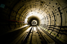 Railroad Tracks In Illuminated Tunnel